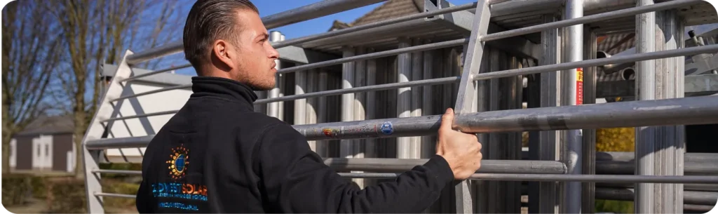 Monteur in ZuidWest Solar-trui zet een aluminium rolsteiger klaar bij een woning